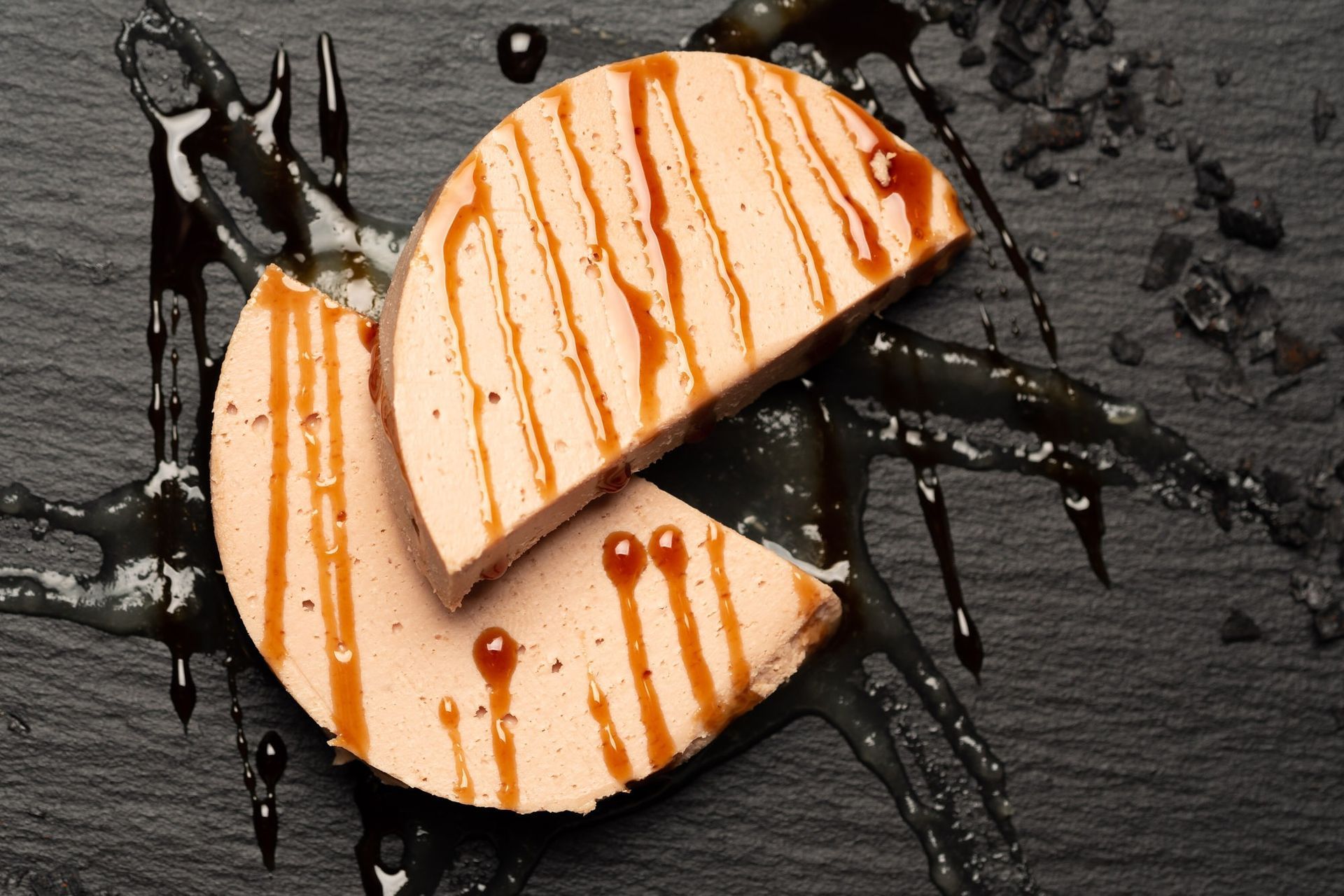 Un trozo de carne con salsa encima está en un plato negro.