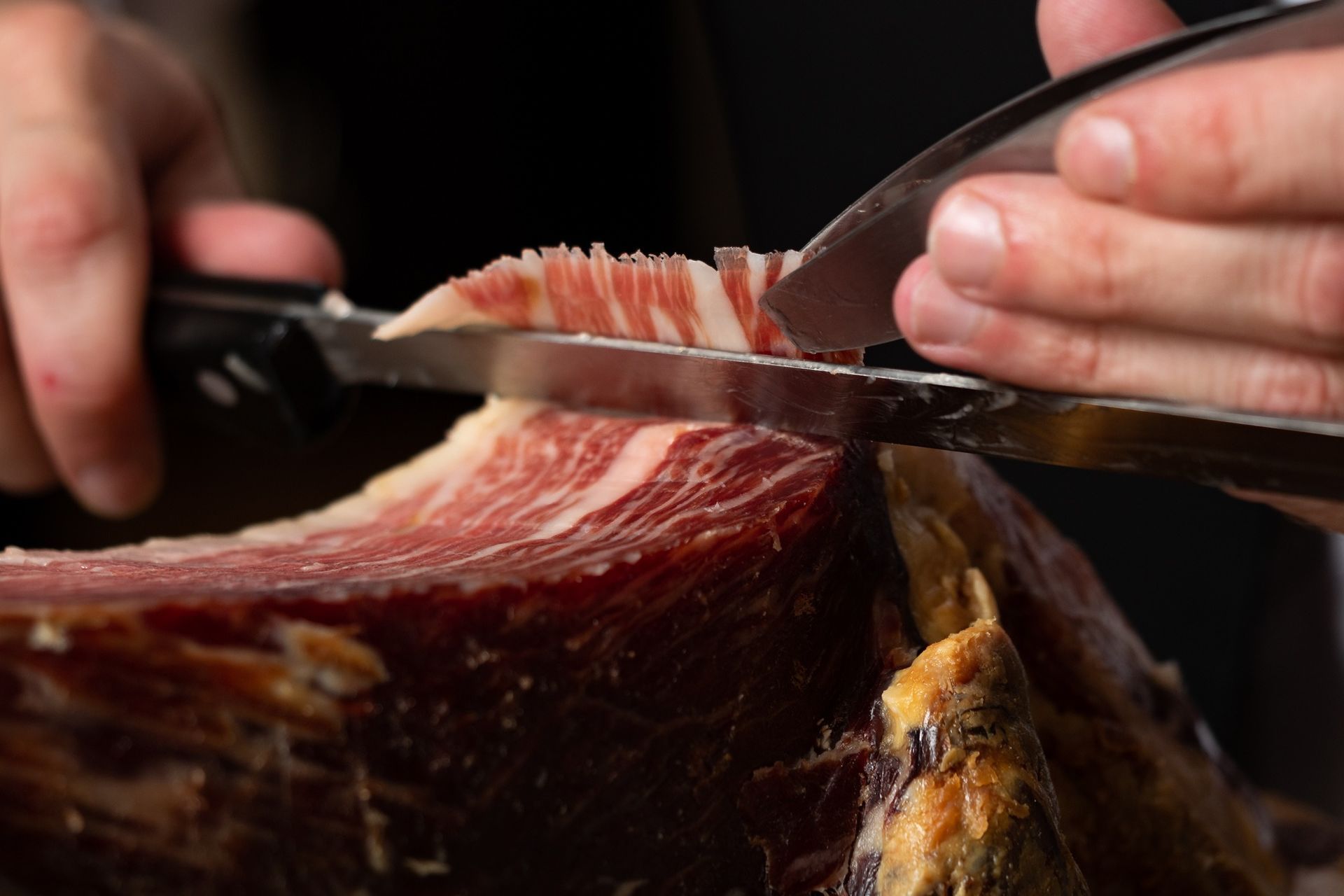 Una persona está cortando un trozo de carne con unas tijeras.