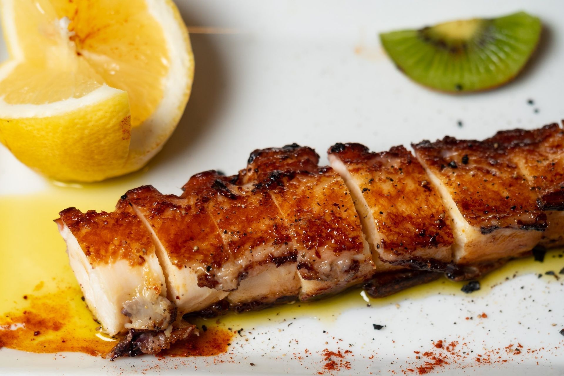 Un primer plano de un plato de comida con rodajas de limón y kiwi.