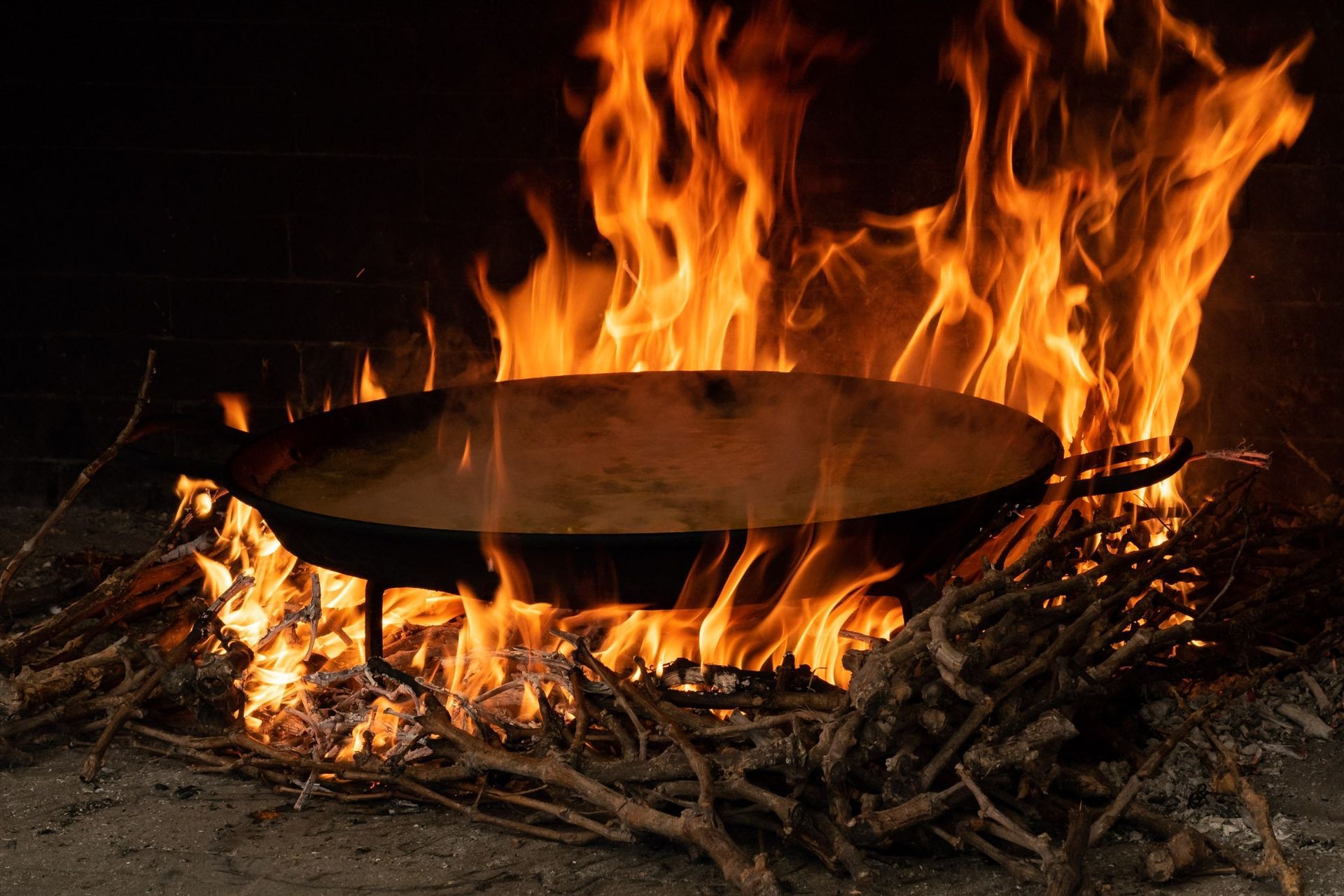Una sartén se está cocinando al fuego en una chimenea.