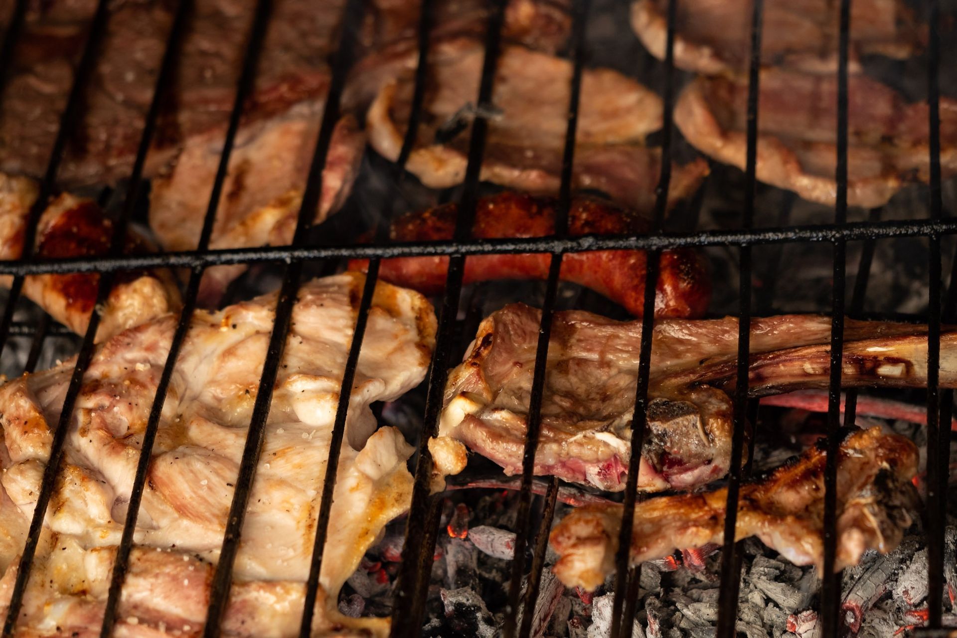 Un primer plano de carne cocinándose en una parrilla.