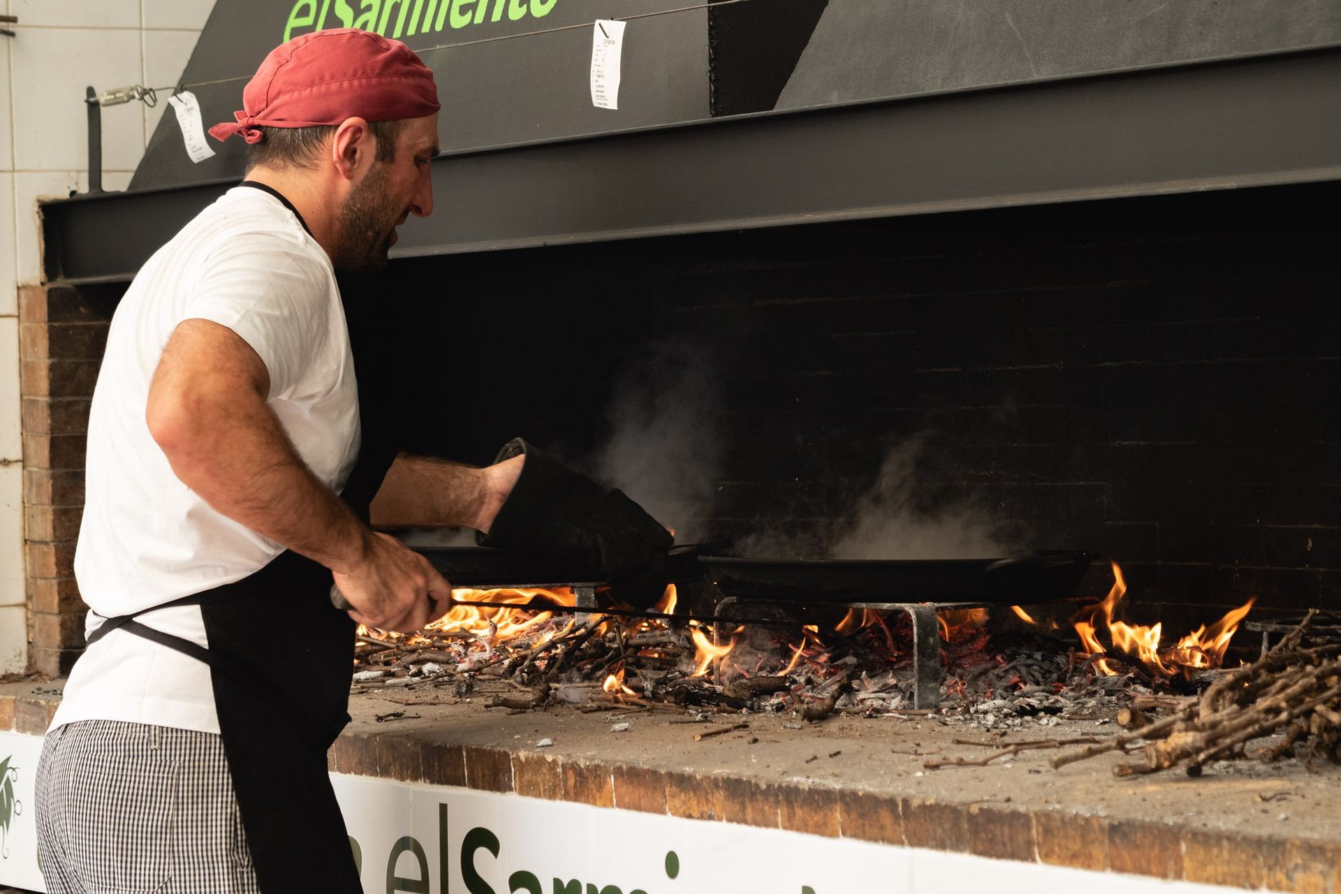 Un hombre está cocinando comida en un horno grande.
