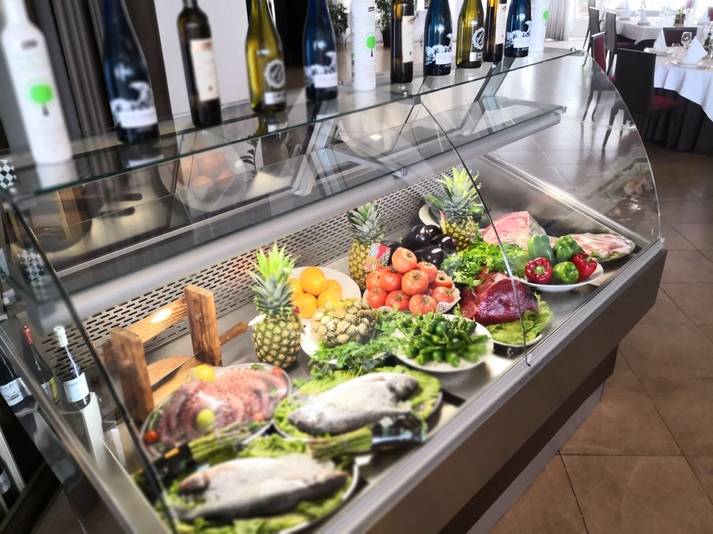 Una vitrina llena de frutas y pescado en un restaurante.