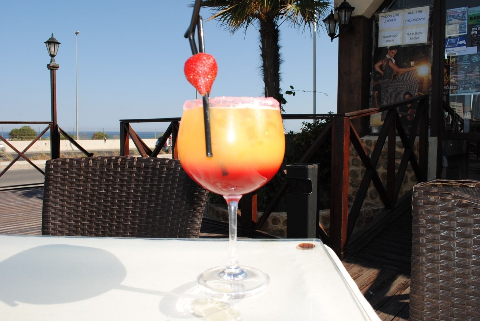 Un vaso de líquido naranja con una pajita dentro.