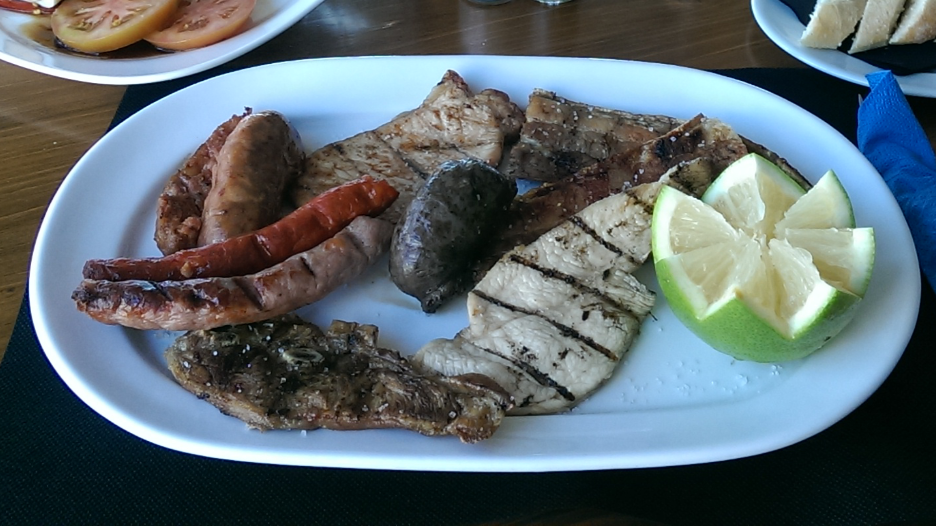 Un plato blanco cubierto con carne y rodajas de limón.