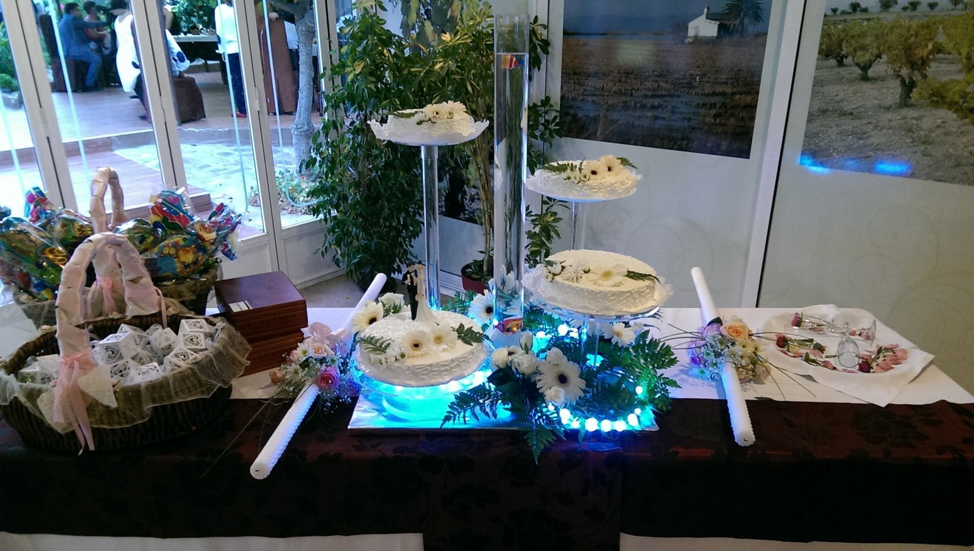 Una mesa con una exhibición de pasteles y flores sobre ella.