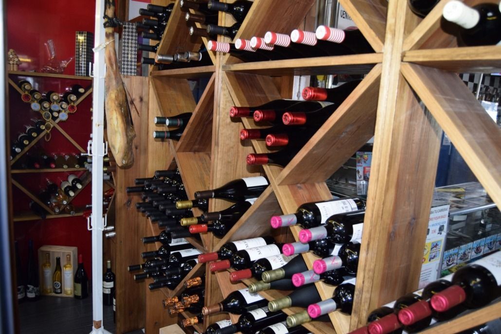 Muchas botellas de vino están alineadas en estantes de madera.