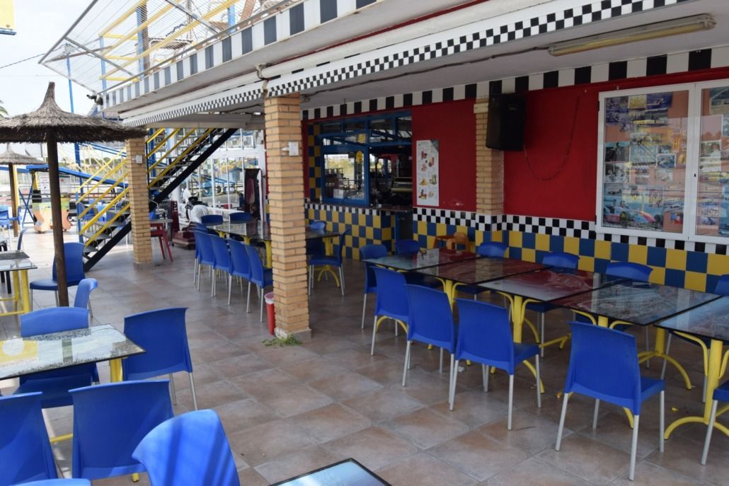 Un restaurante con sillas y mesas azules y una pared a cuadros.
