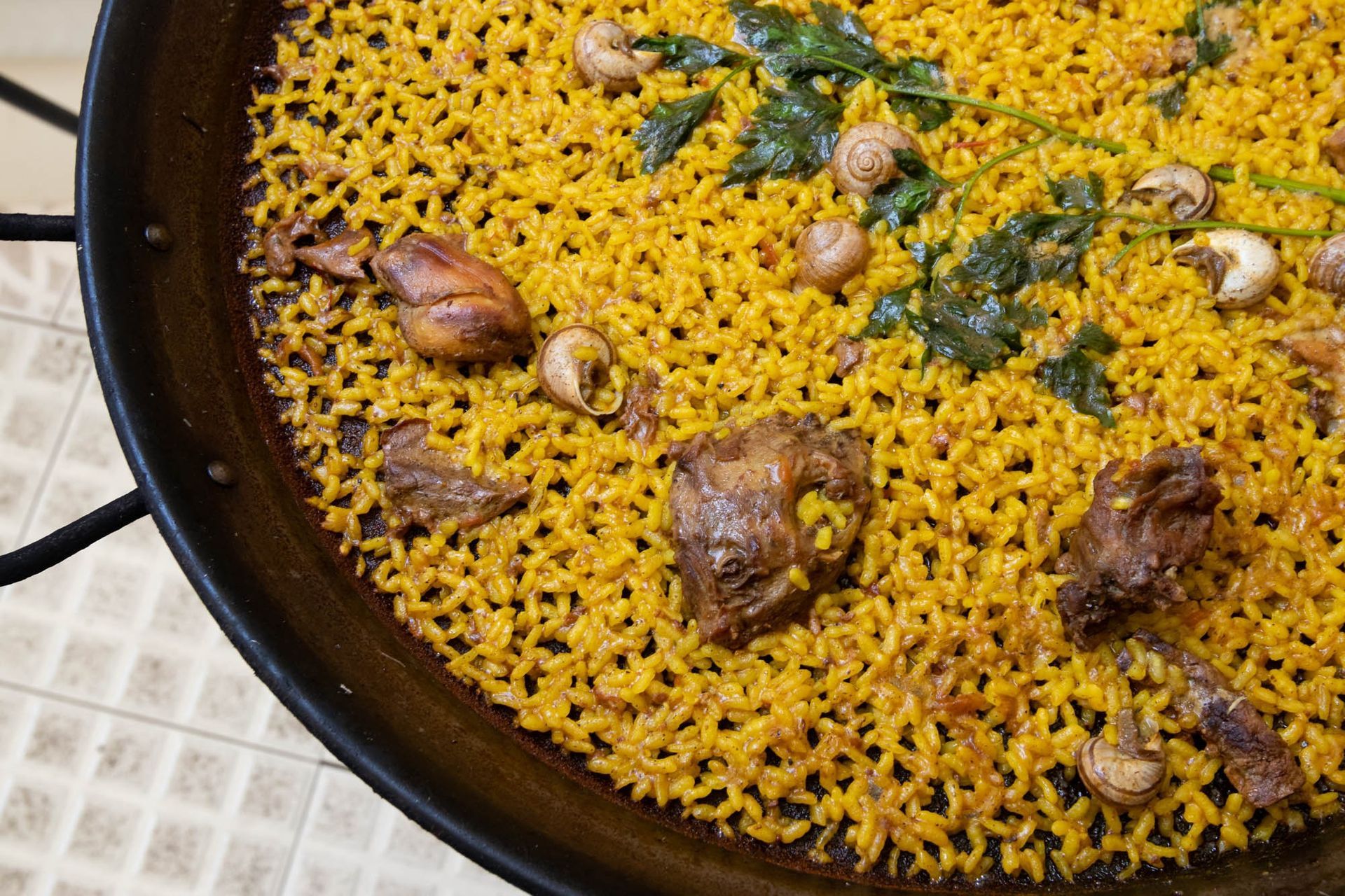 Una sartén llena de arroz y carne sobre una mesa.
