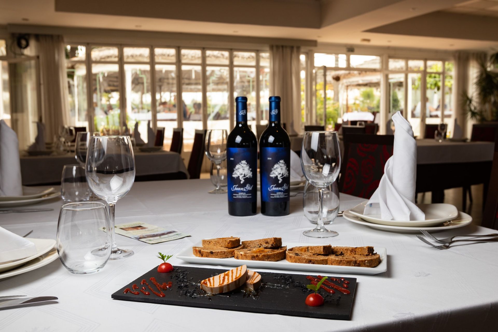 Dos botellas de vino están sentadas en una mesa en un restaurante.