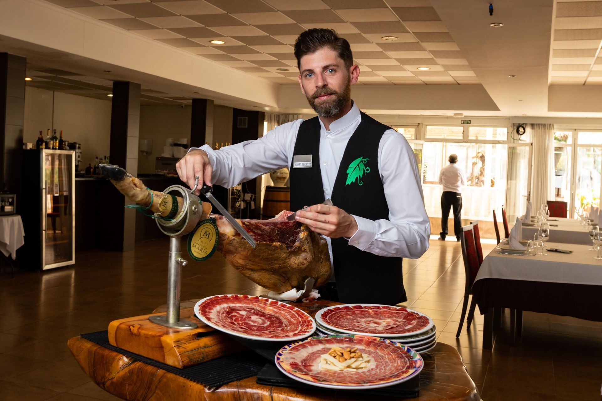 Un hombre está cortando un trozo de carne en un restaurante.