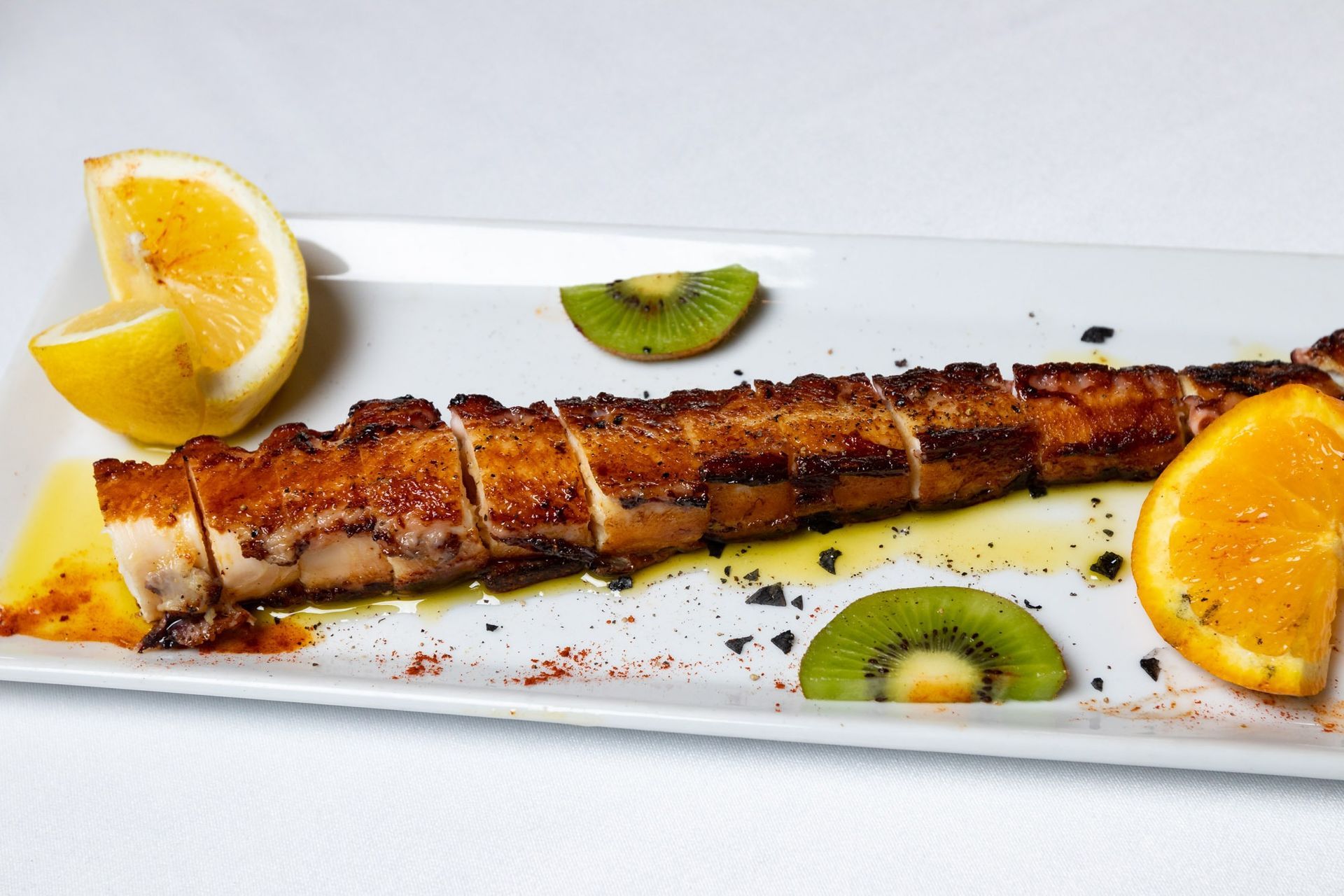 Un plato de comida con rodajas de kiwi y naranjas encima.