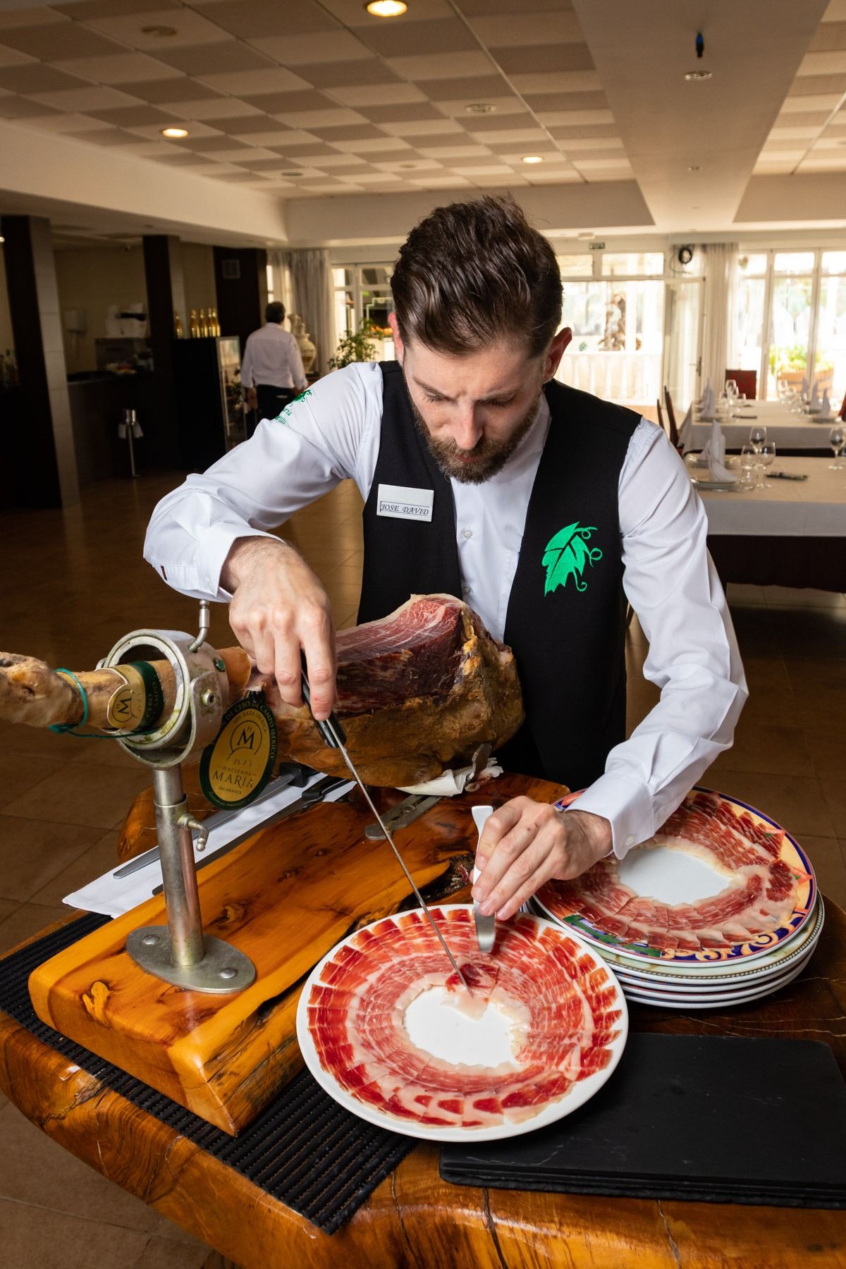 Un hombre está cortando un gran trozo de carne en una mesa.