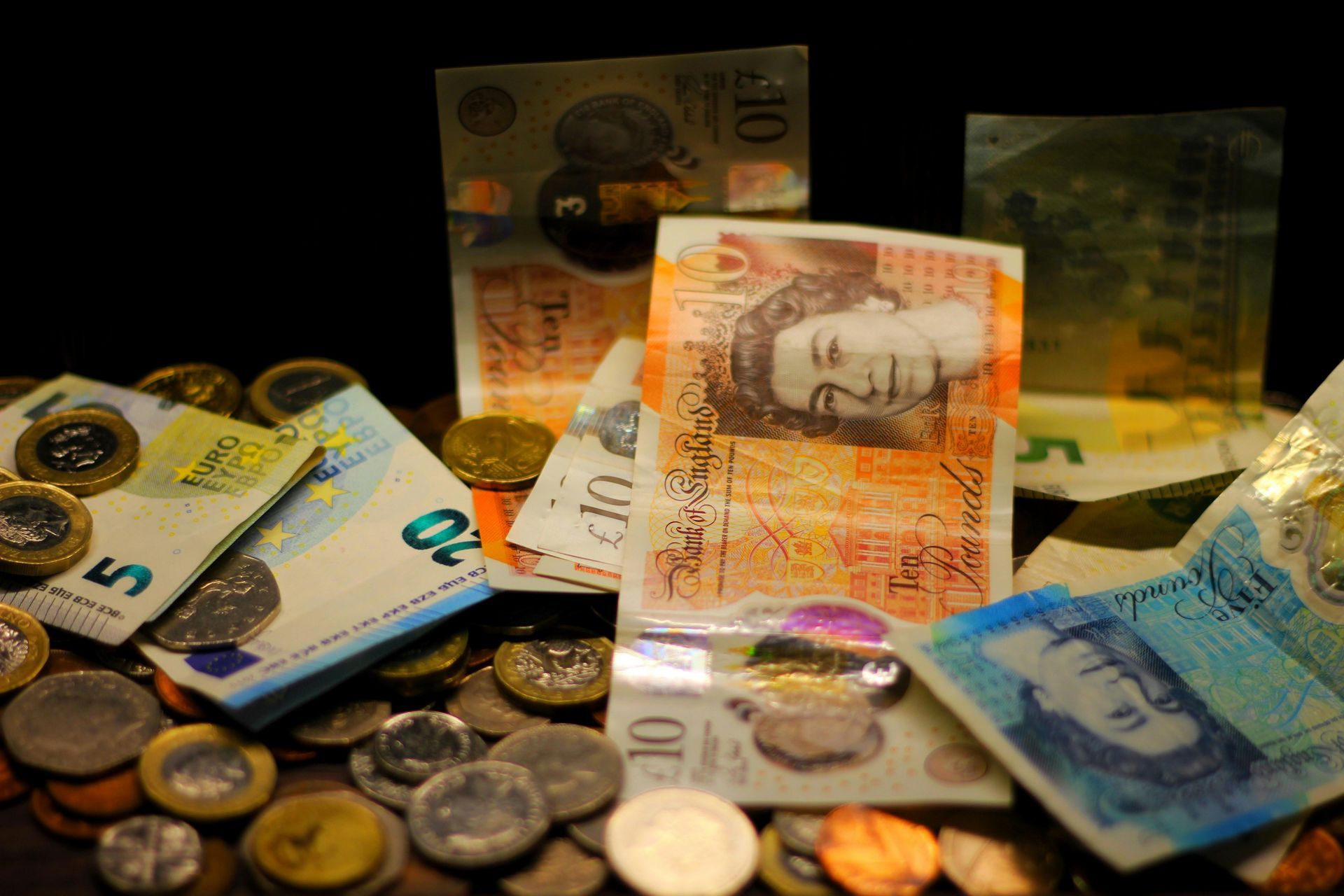 A pile of money and coins including a 10 pound note