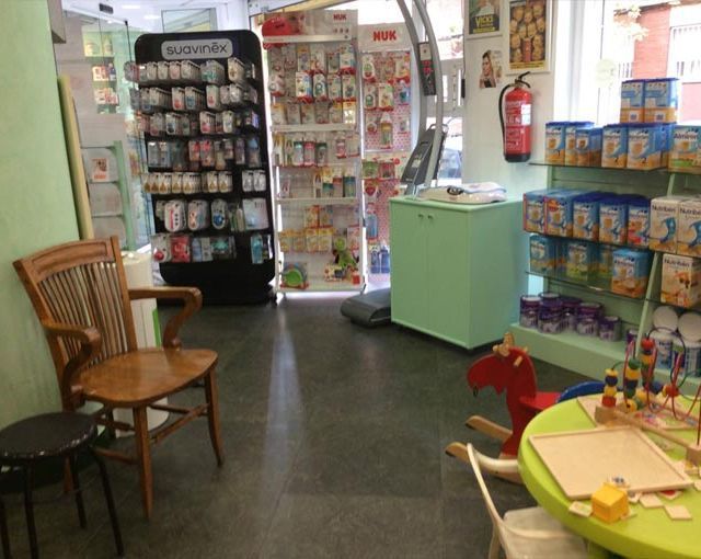 Una farmacia con un caballito de madera y una mesa.
