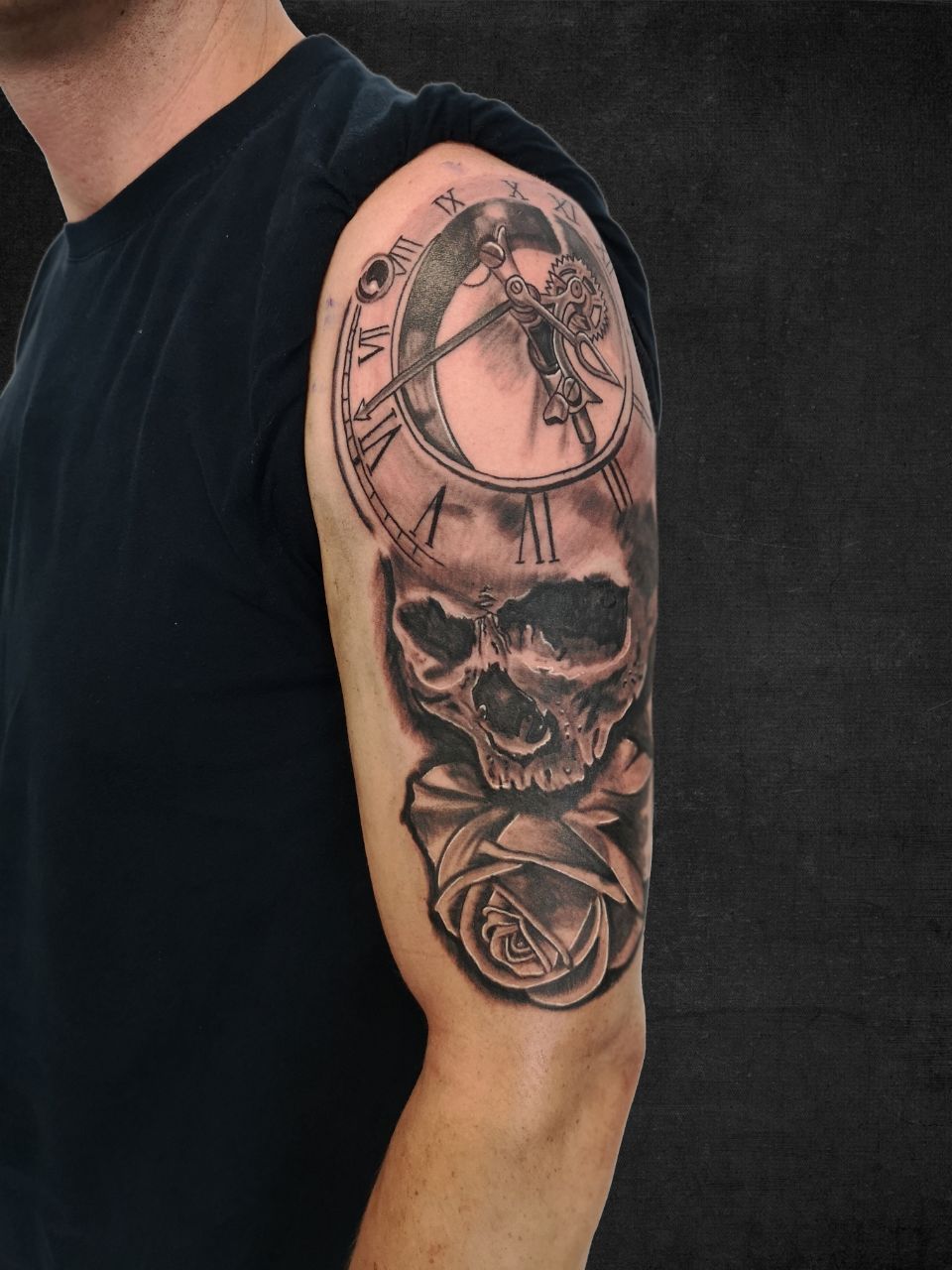 Tattoo in Schwarz und Grau auf dem Oberarm