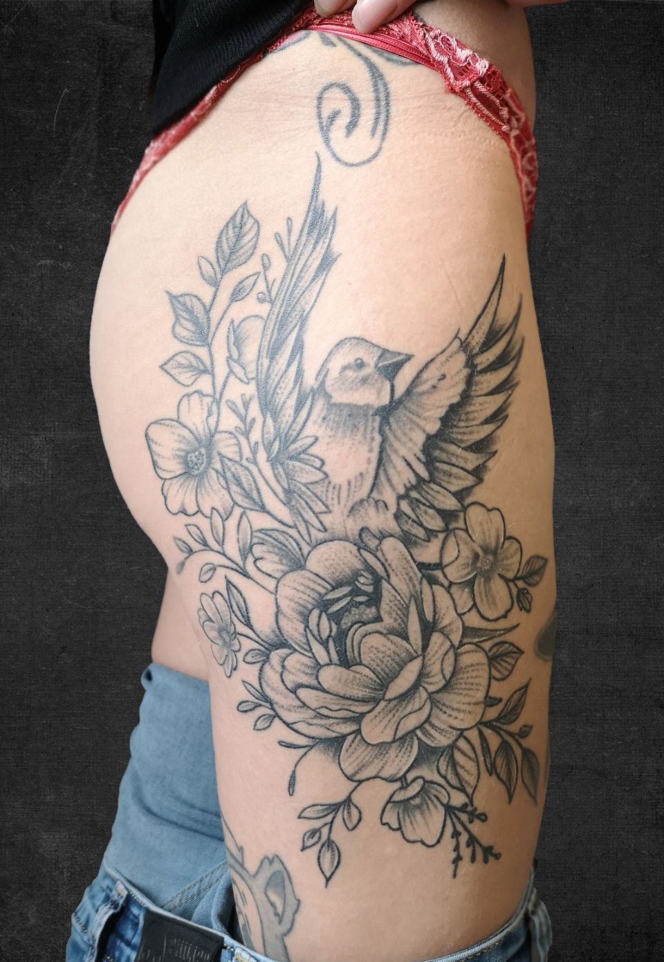 Tattoo in Schwarz und Grau auf dem Oberschenkel