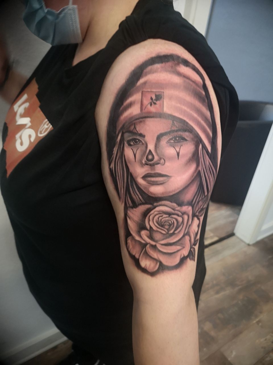 Portrait-Tattoo in Schwarz und Grau auf dem Oberarm
