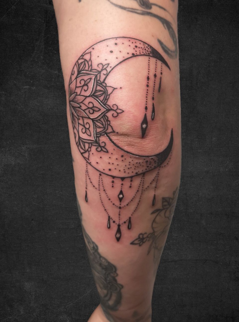 Fineline-Tattoo in Schwarz und Grau auf dem Ellbogen