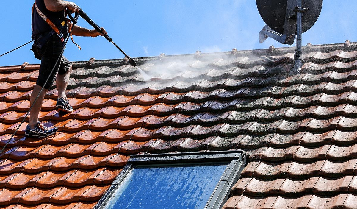 Homme qui nettoie une toiture