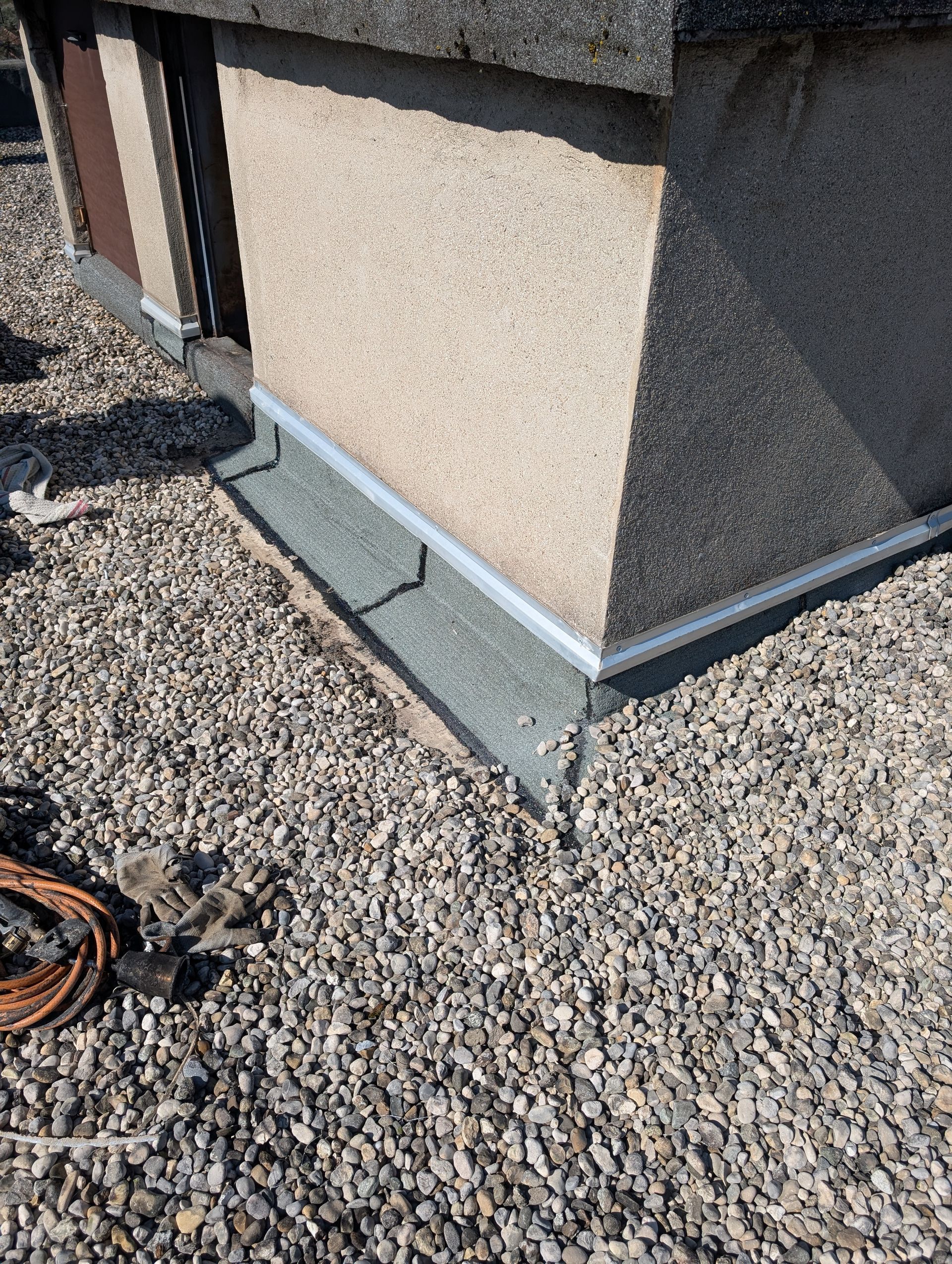 Des graviers entourent la base d'une cheminée sur un toit-terrasse.