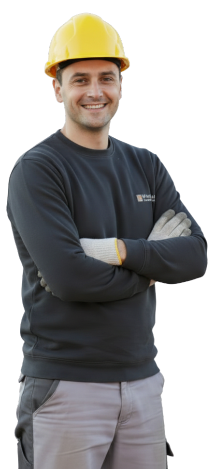 Un artisan souriant porte un casque de chantier jaune.