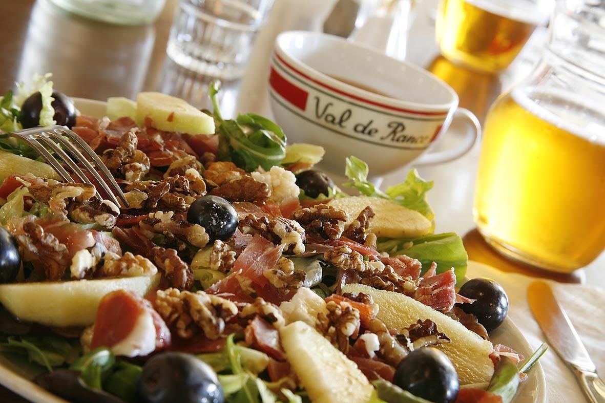 Salade composée à côté de plusieurs verres.