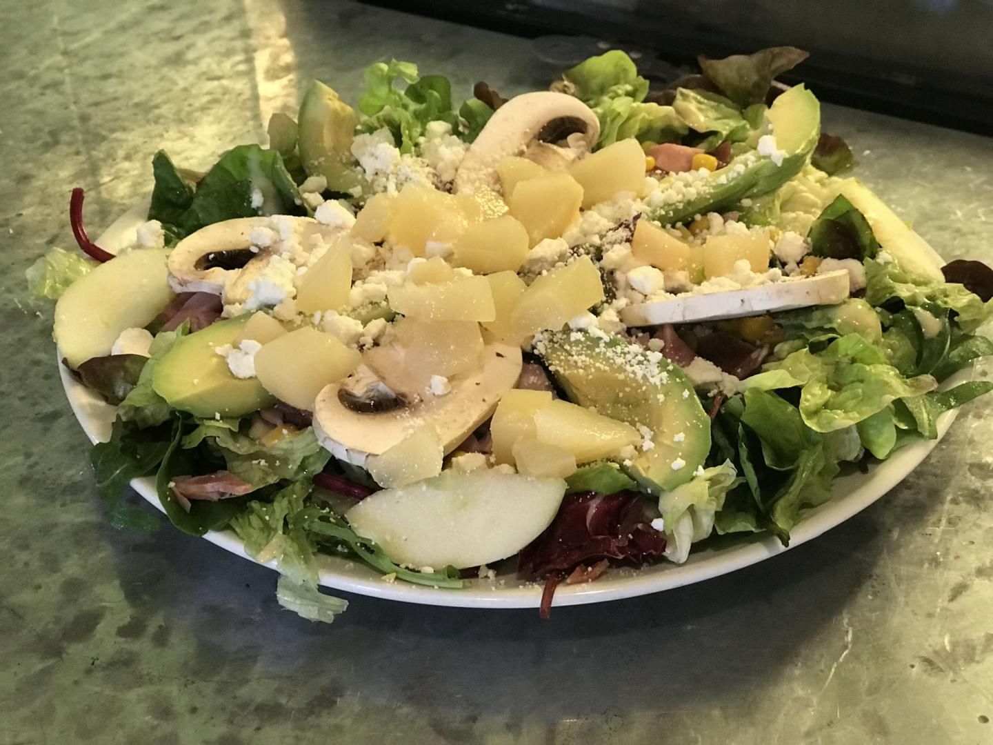 Salade composée servie sur une assiette blanche.