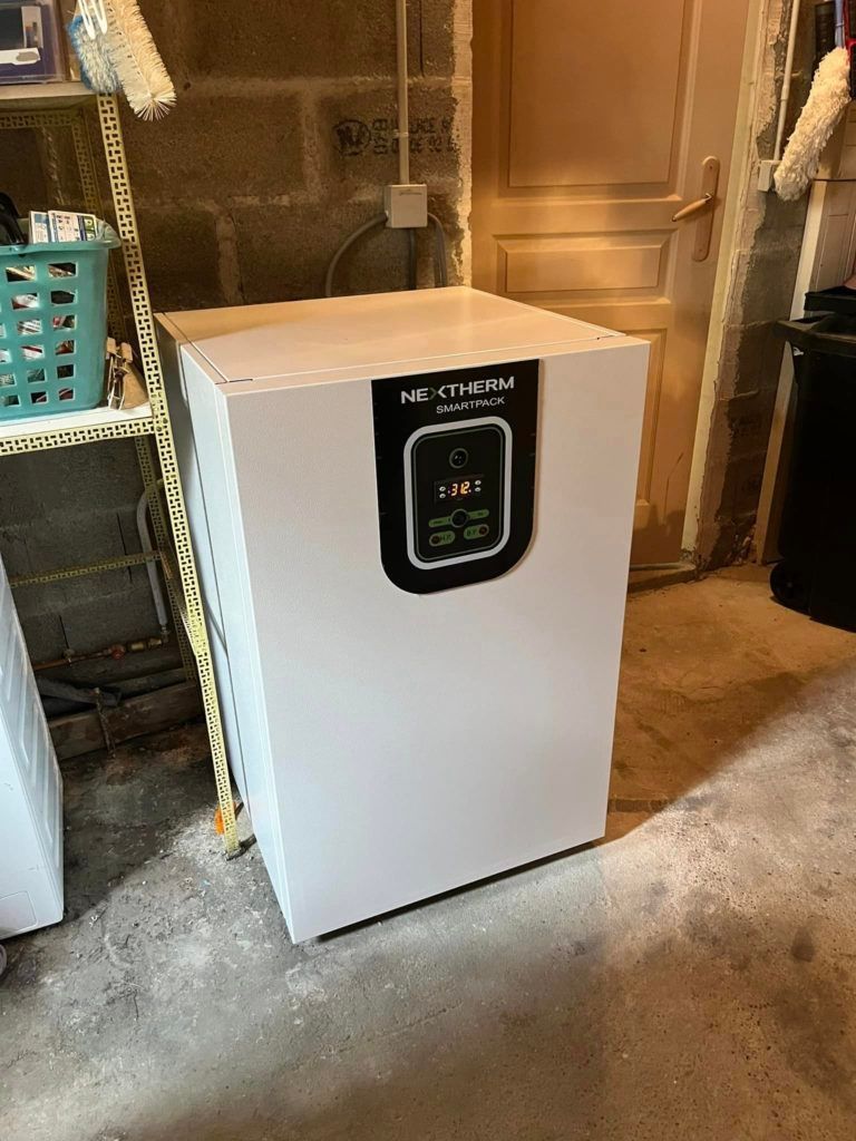Une chaudière électrique Neathermo blanche avec un panneau de commande noir, installée dans un sous-sol.