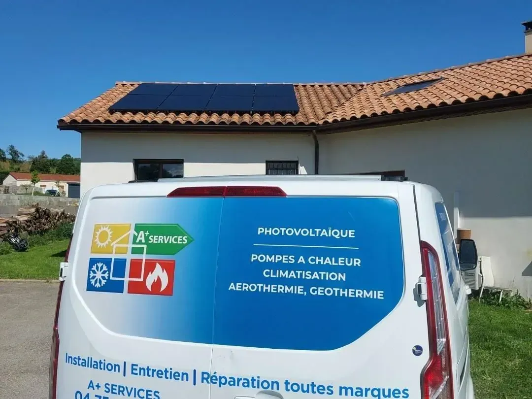 Une camionnette de chantier garée devant une maison équipée de panneaux solaires, affichant des informations sur les services de chauffage, ventilation et climatisation et d'énergie solaire sur sa porte arrière.
