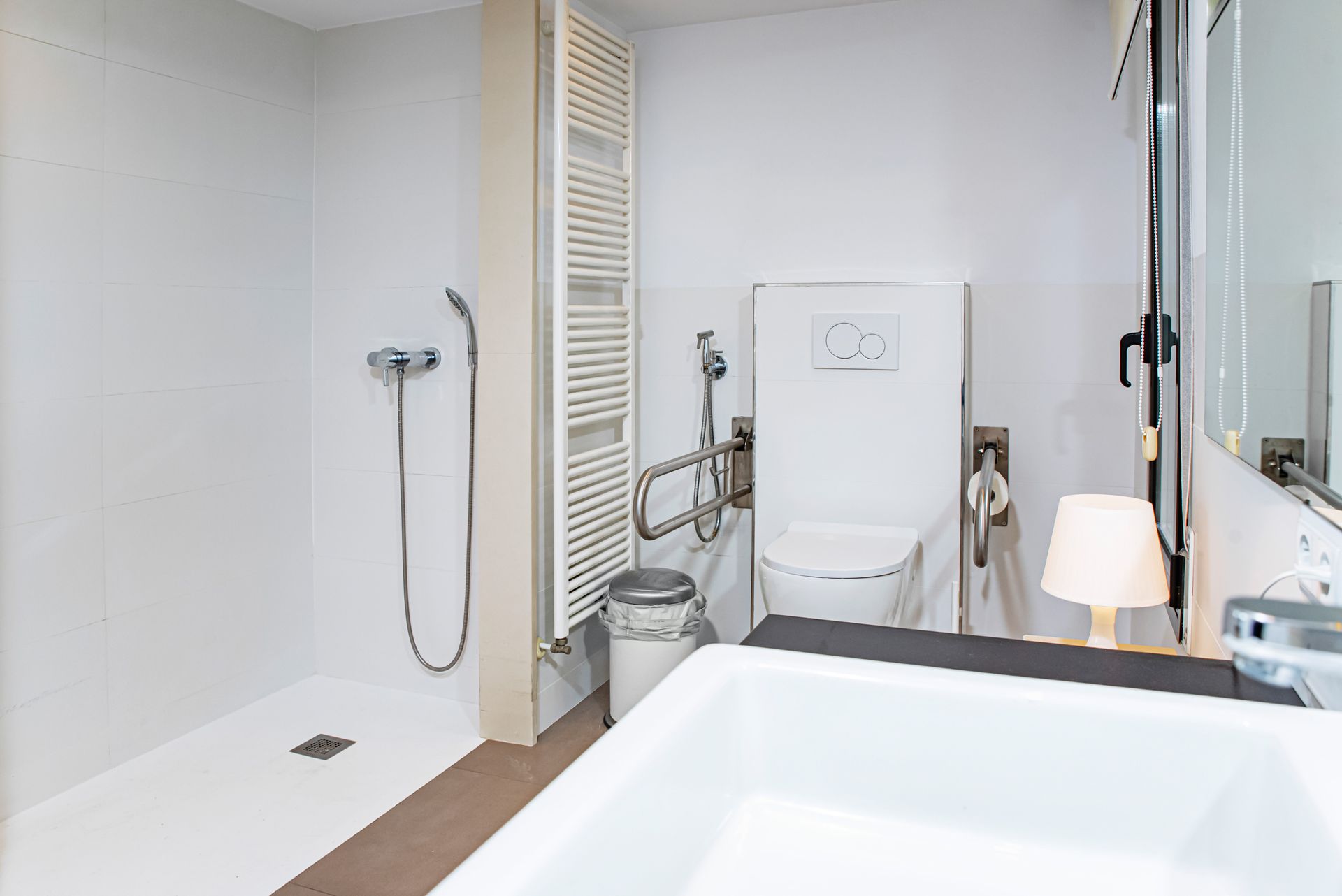 Salle de bains moderne blanche avec douche à l’italienne, toilettes et baignoire