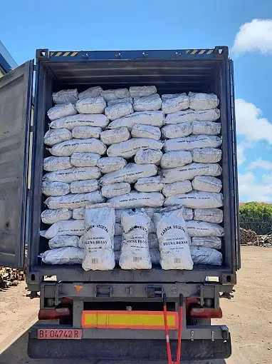 La parte trasera de un camión lleno de bolsas de carbón.