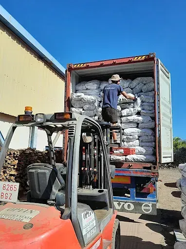 Un hombre está cargando un contenedor con una carretilla elevadora.