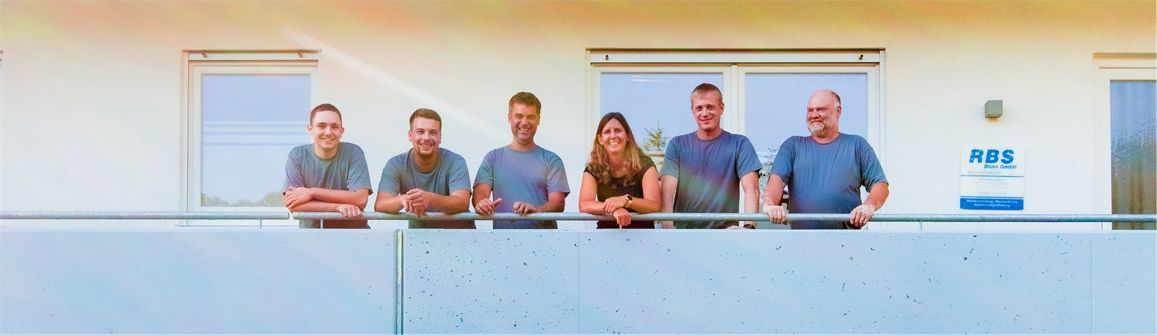 Eine Gruppe von Menschen posiert auf einem Balkon für ein Foto.