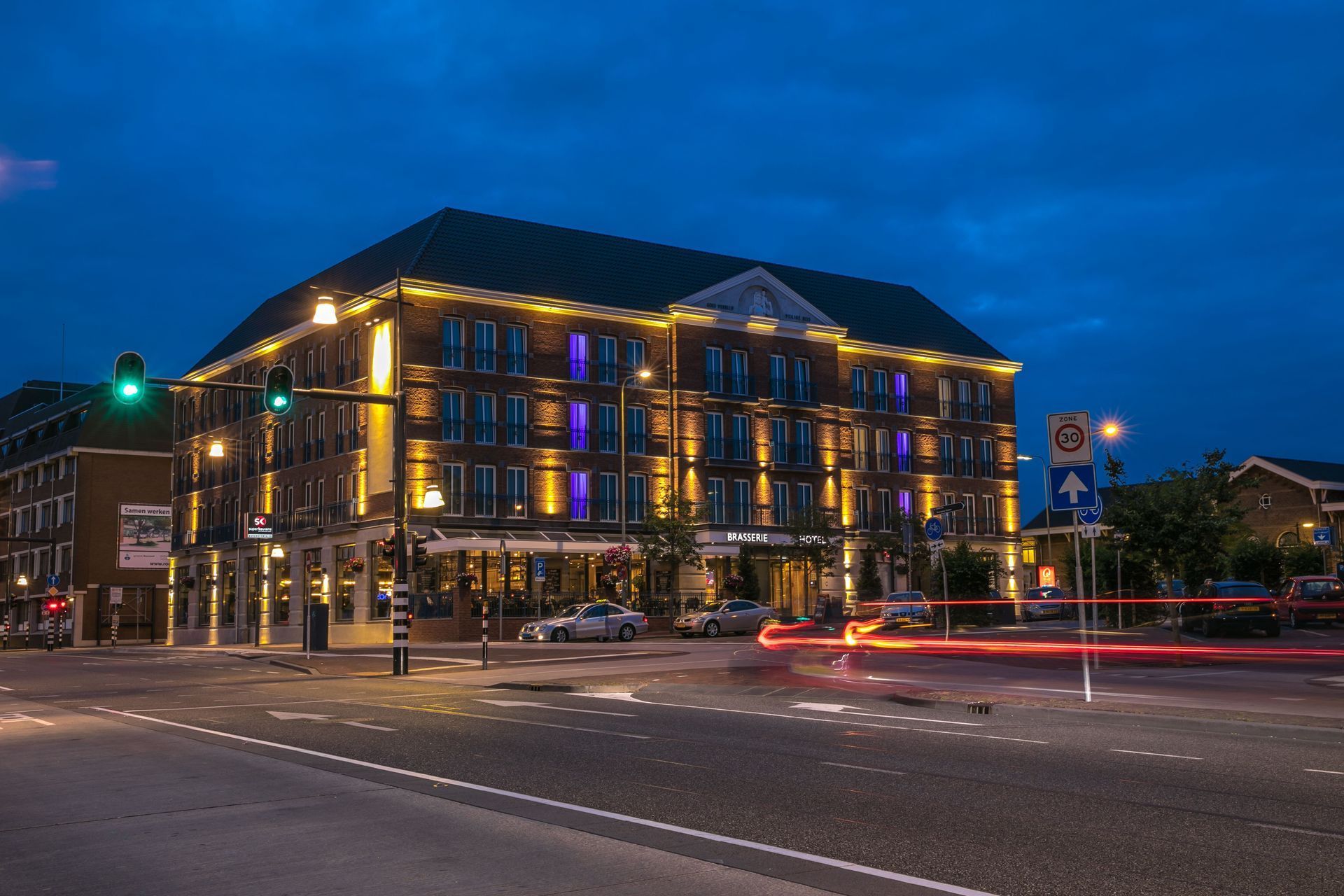 A large building is lit up at night in a city.
