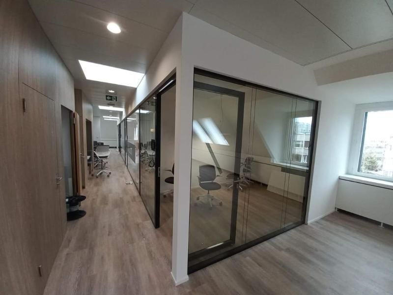 Ein Flur in einem Bürogebäude mit einer Glaswand zwischen zwei Räumen. Foto von der Popaj GmbH