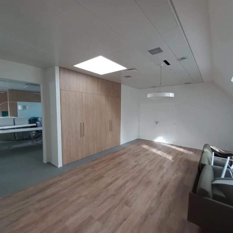 Ein Wohnzimmer mit Hartholzböden und weissen Wänden. Foto von der Popaj GmbH