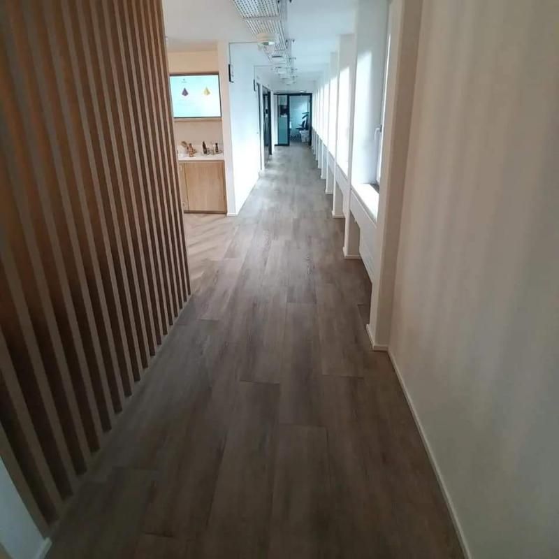 Ein langer Flur mit Holzboden und weisser Wand. Foto von der Popaj GmbH