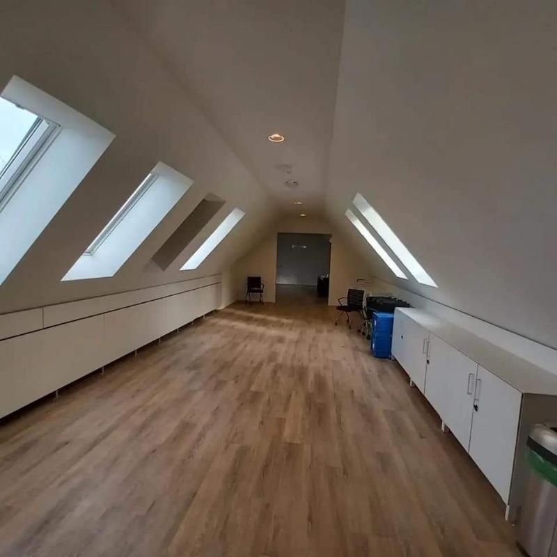 Ein leerer Dachboden mit Hartholzböden und weissen Schränken. Foto von der Popaj GmbH