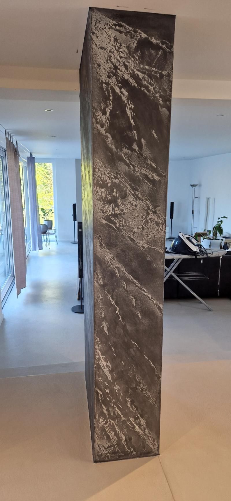 In der Mitte eines Wohnzimmers steht eine grosse Säule. Foto von der Popaj GmbH