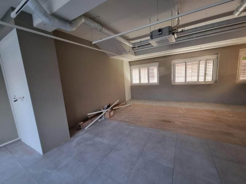 Ein leerer Raum mit vielen Fenstern und einem Projektor an der Decke. Foto von der Popaj GmbH