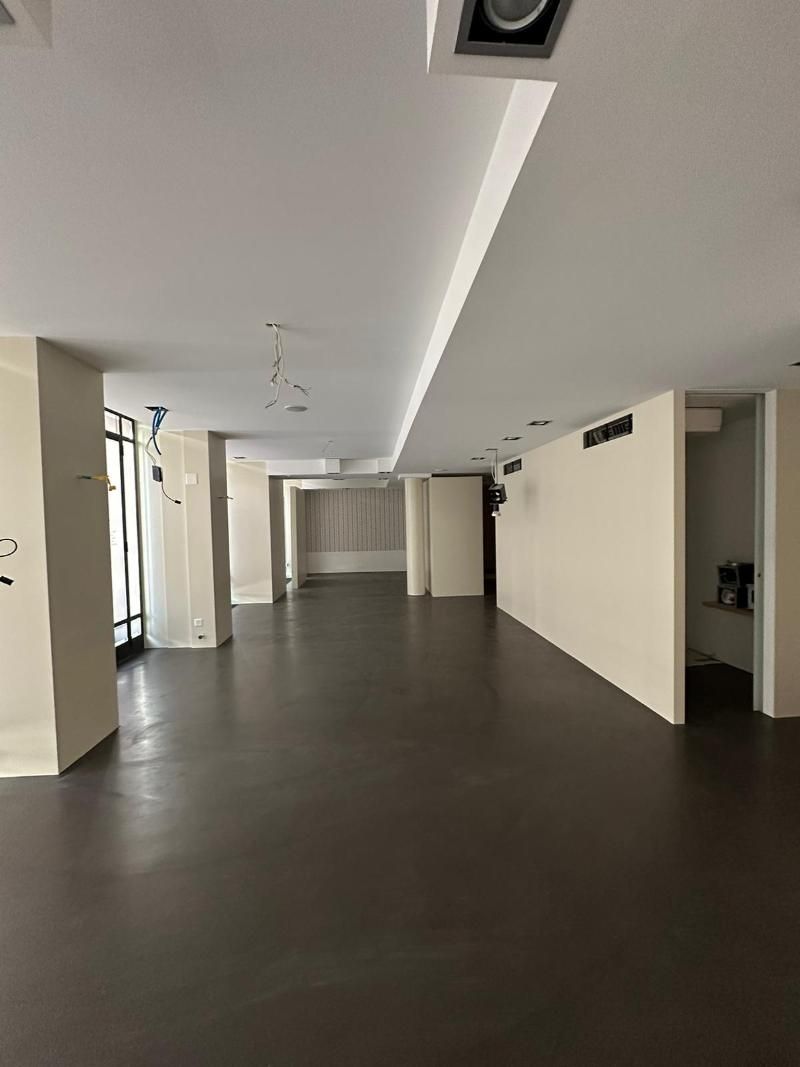 Ein grosser leerer Raum mit braunem Boden und weissen Wänden. Foto von der Popaj GmbH