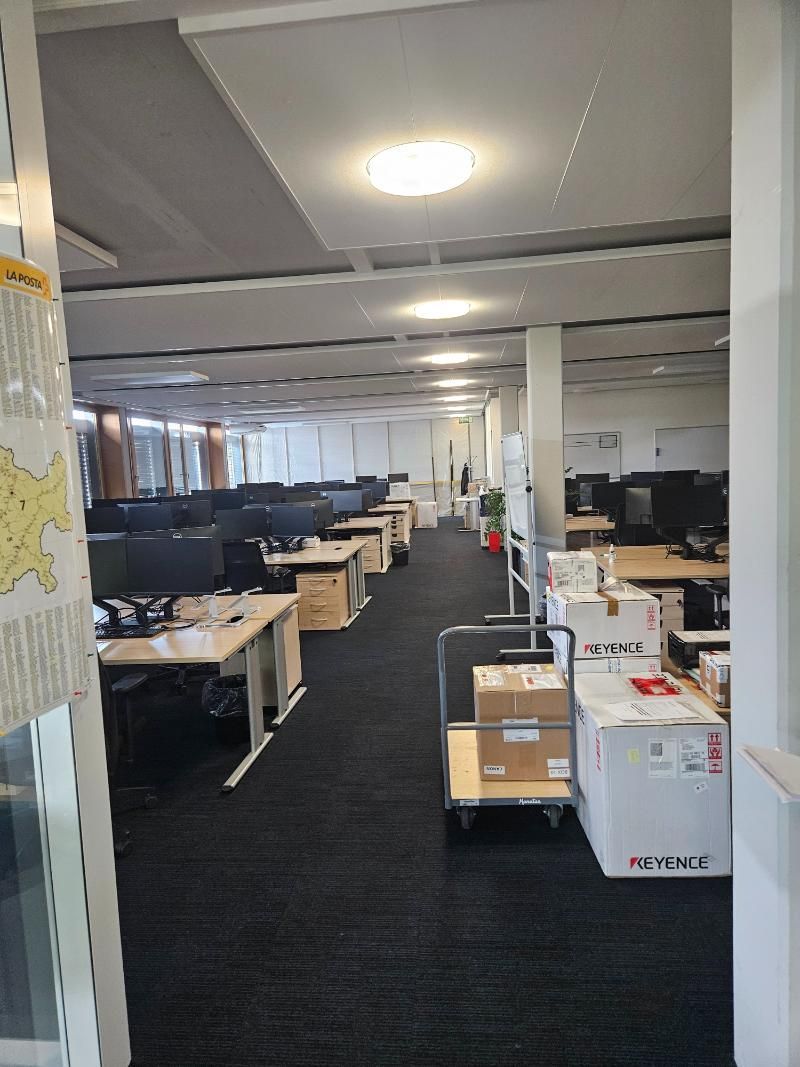 Ein grosses leeres Büro mit vielen Schreibtischen und Kisten auf dem Boden. Foto von der Popaj GmbH