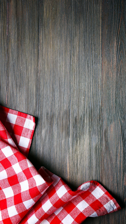 Tissu à carreaux rouges et blancs sur une surface en bois foncé.