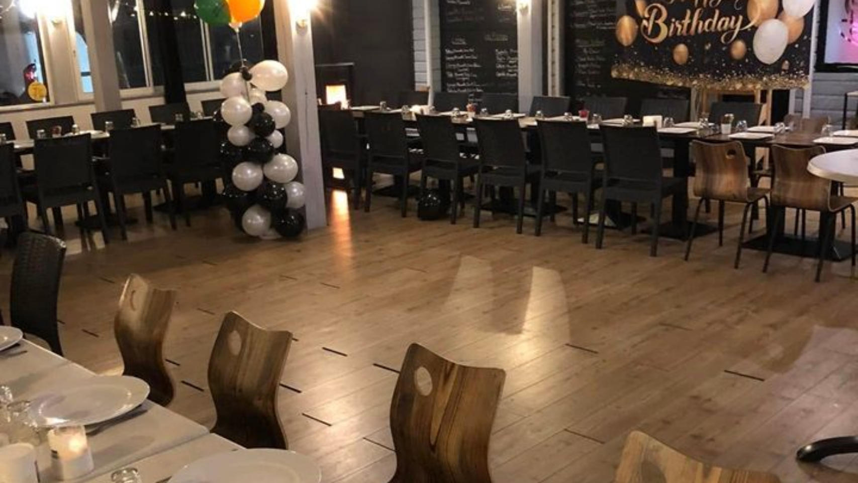 Installation d'une fête d'anniversaire dans un restaurant avec des chaises, tables et ballons
