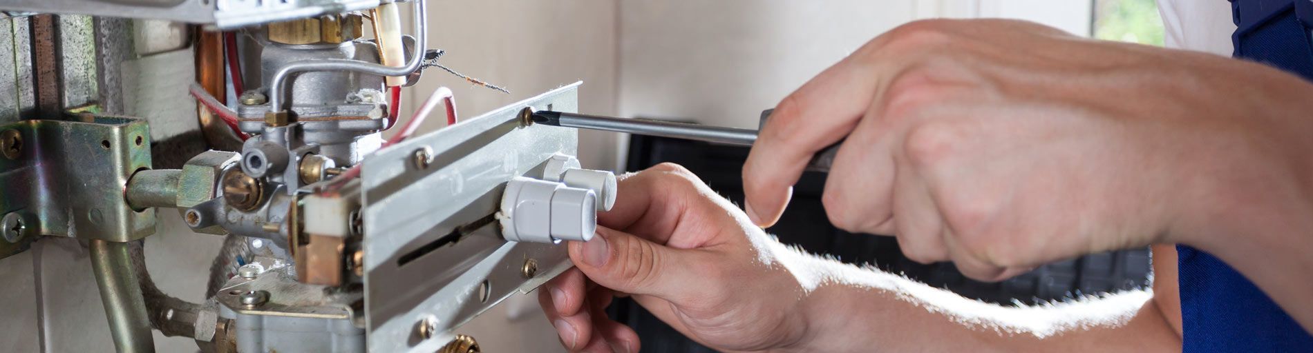 Una persona utiliza un destornillador para trabajar en una máquina.