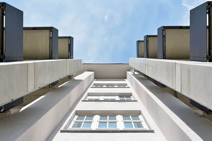 Mirando hacia arriba a un edificio con un cielo azul en el fondo