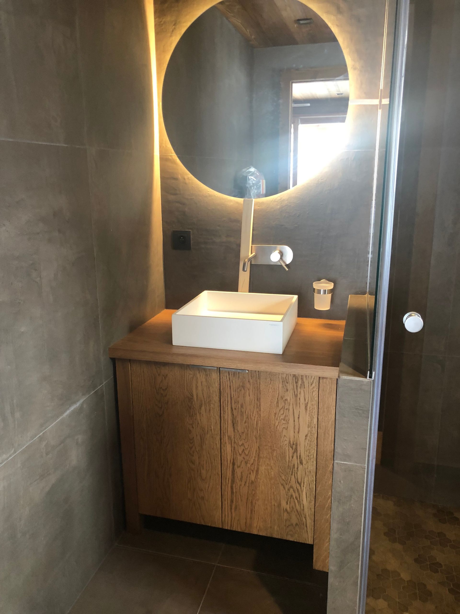 Coin lavabo avec une vasque posée sur un meuble en bois