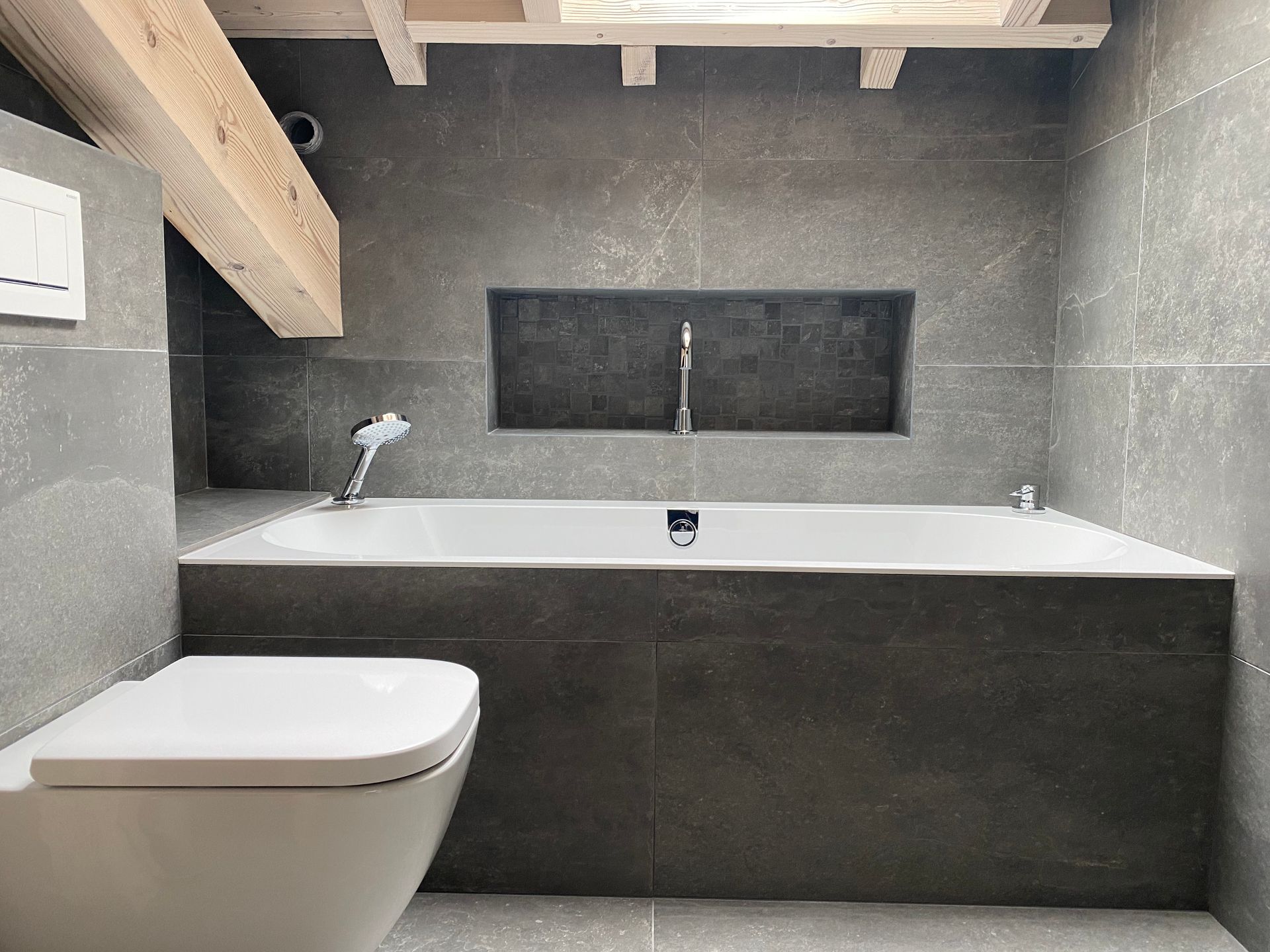 Toilette et une baignoire avec du carrelage gris au fond de la pièce