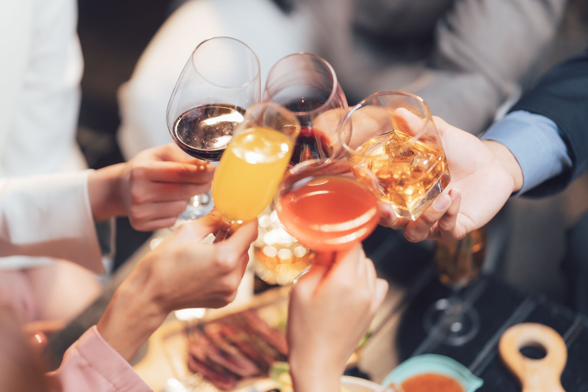 Des amis trinquent avec des cocktails colorés à une table de fête